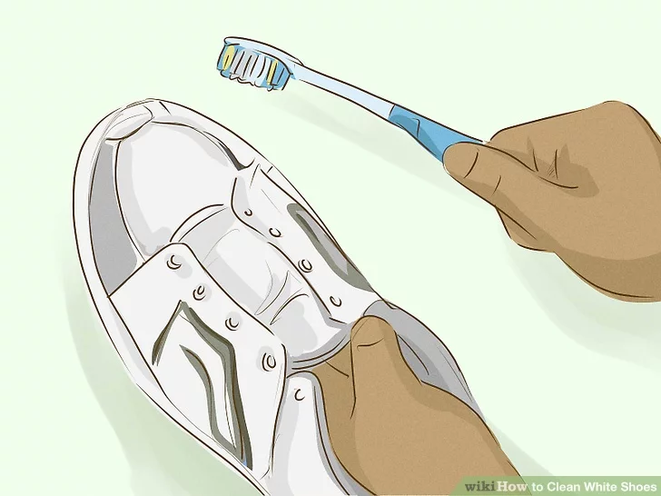 Cho bột baking soda vào giày bằng bàn chải đánh răng